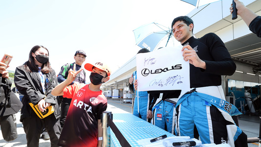 与来到赛车场的许多车迷互动